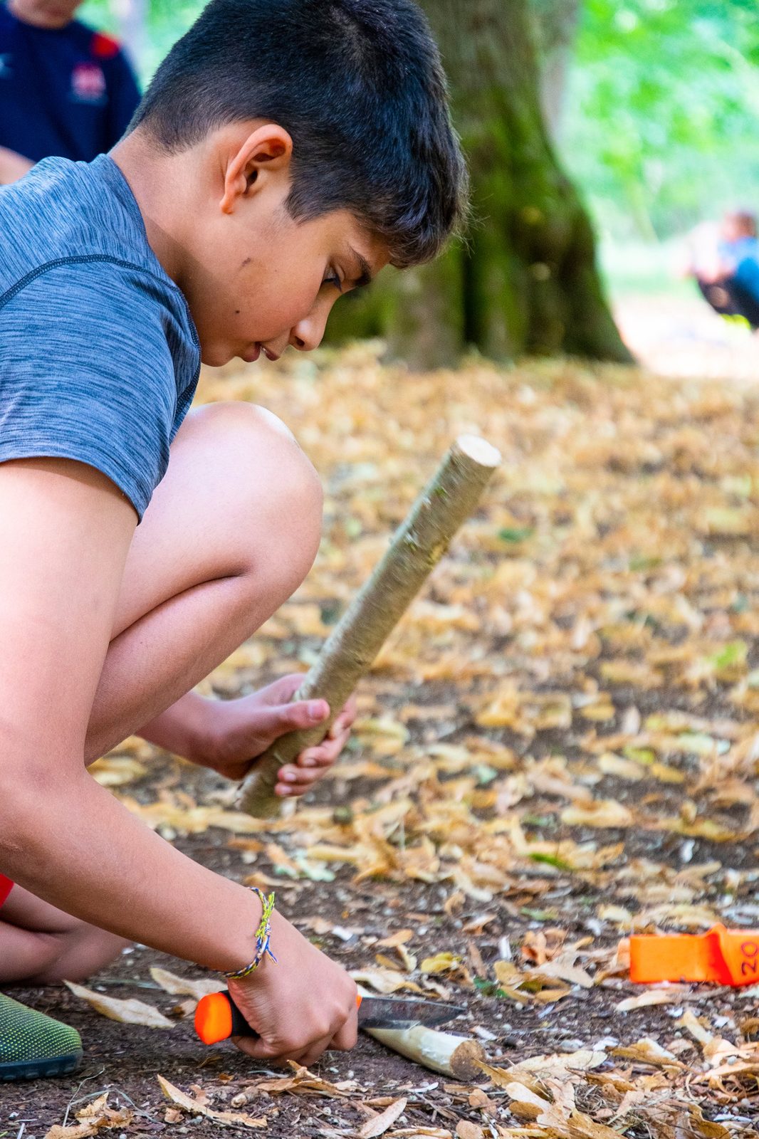 Student whittling a stick during a safe knife and tool session