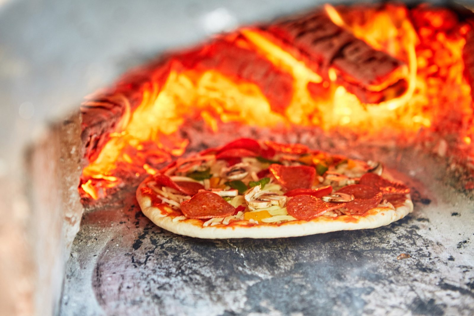 Woodfired pizza cooking in a wood-burning oven at a bushcraft school residential